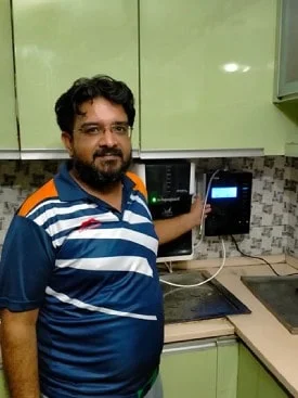 Male standing next to his trusted Chanson Quality Water Purifier