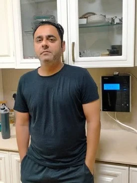Man operating the advanced Chanson Quality Water Purifier in his home